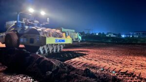 memadatkan permukaan tanah merah yang basah di malam hari