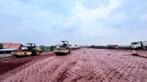 memadatkan lapisan tanah merah pada dasar jalan di lokasi pembangunan Proyek Tol Akses Patimban