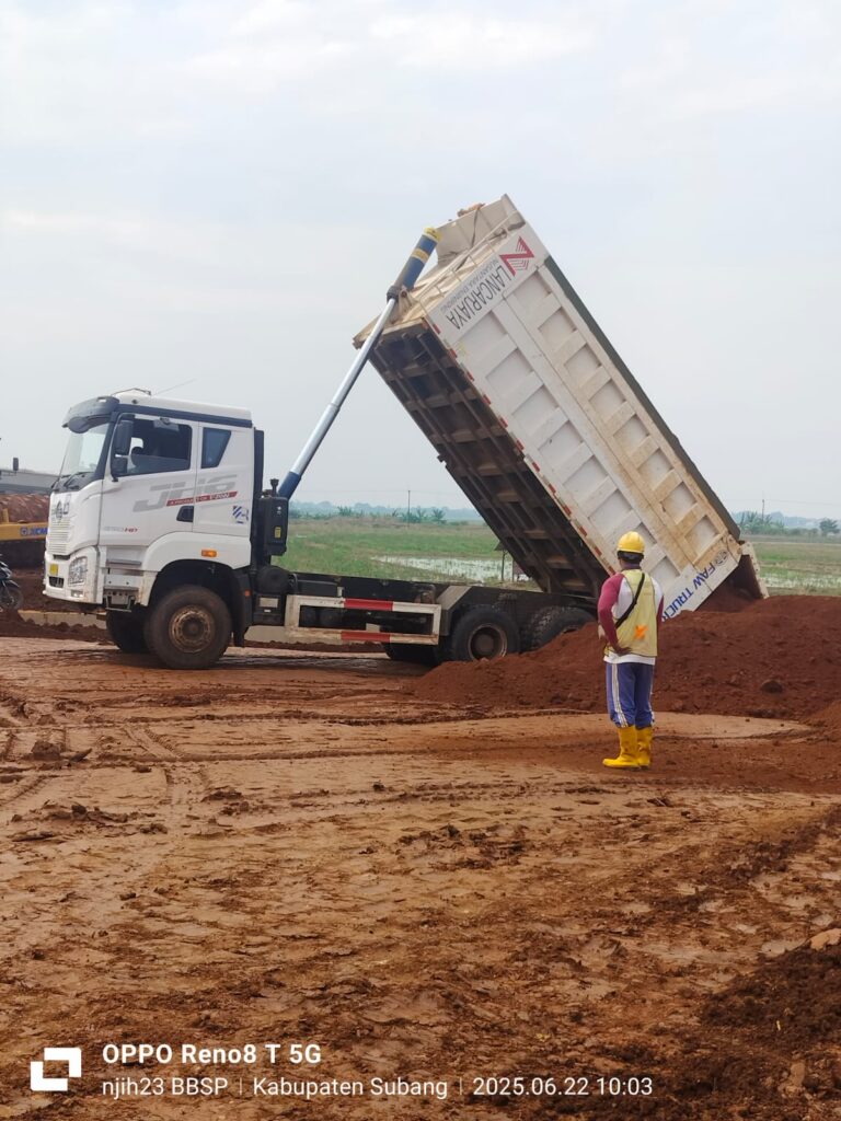 Truk dump PT BBSP menumpahkan tanah untuk penimbunan di lokasi Proyek Tol Akses Patimban Paket 1, Subang, diawasi oleh pekerja lapangan. Ilustrasi pekerjaan tanah di lokasi proyek infrastruktur